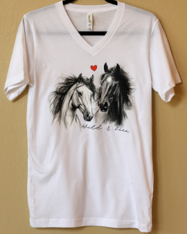White v-neck t-shirt with a portrait of two horses together and a red heart above them. Small script text reads: wild and free.